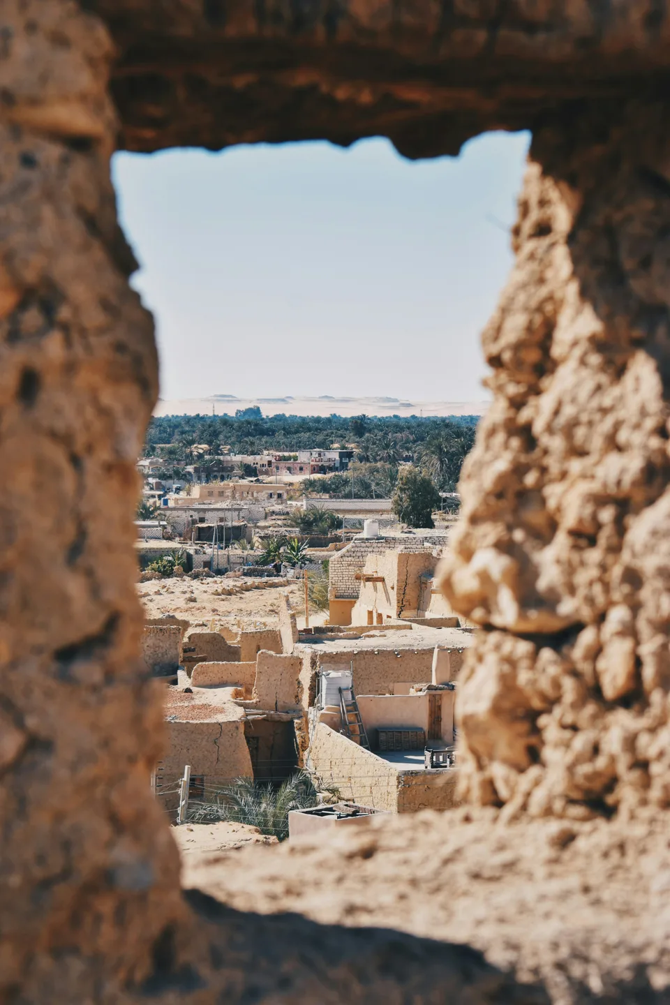 View across the Siwa oasis through a weathered stone opening