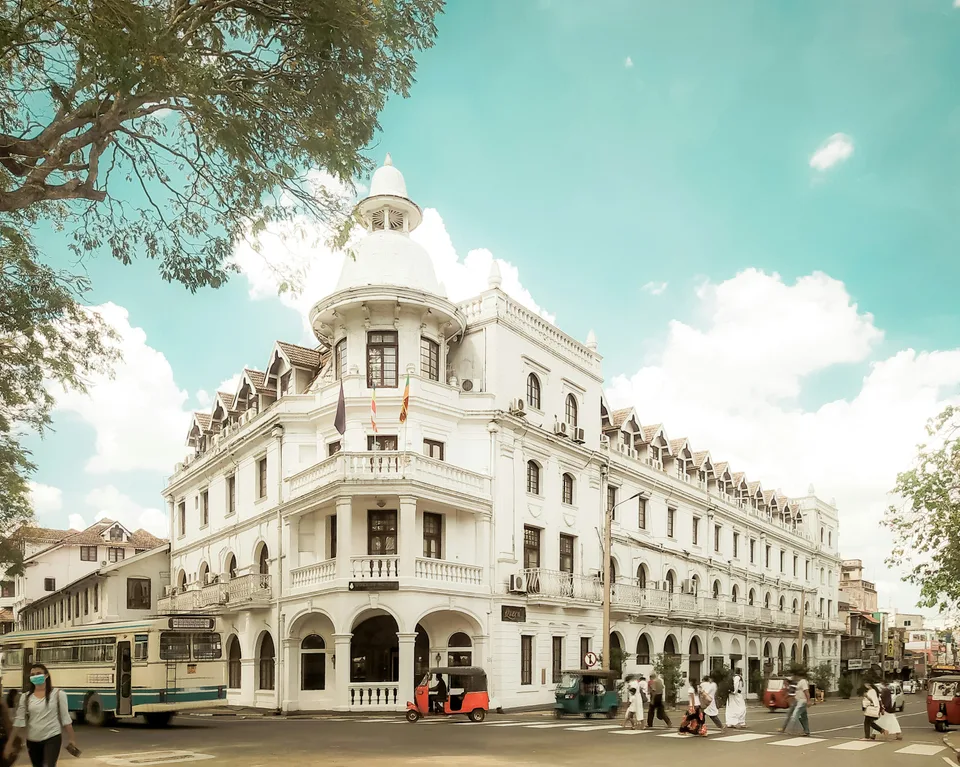 An elegant white historic building on a street in Kandy