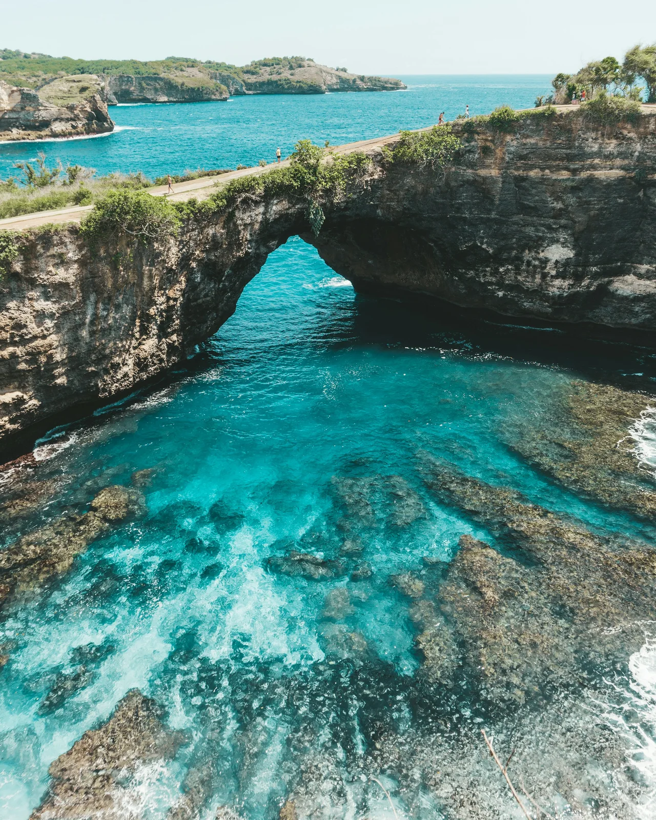 A natural stone arch enclosing clear blue ocean water