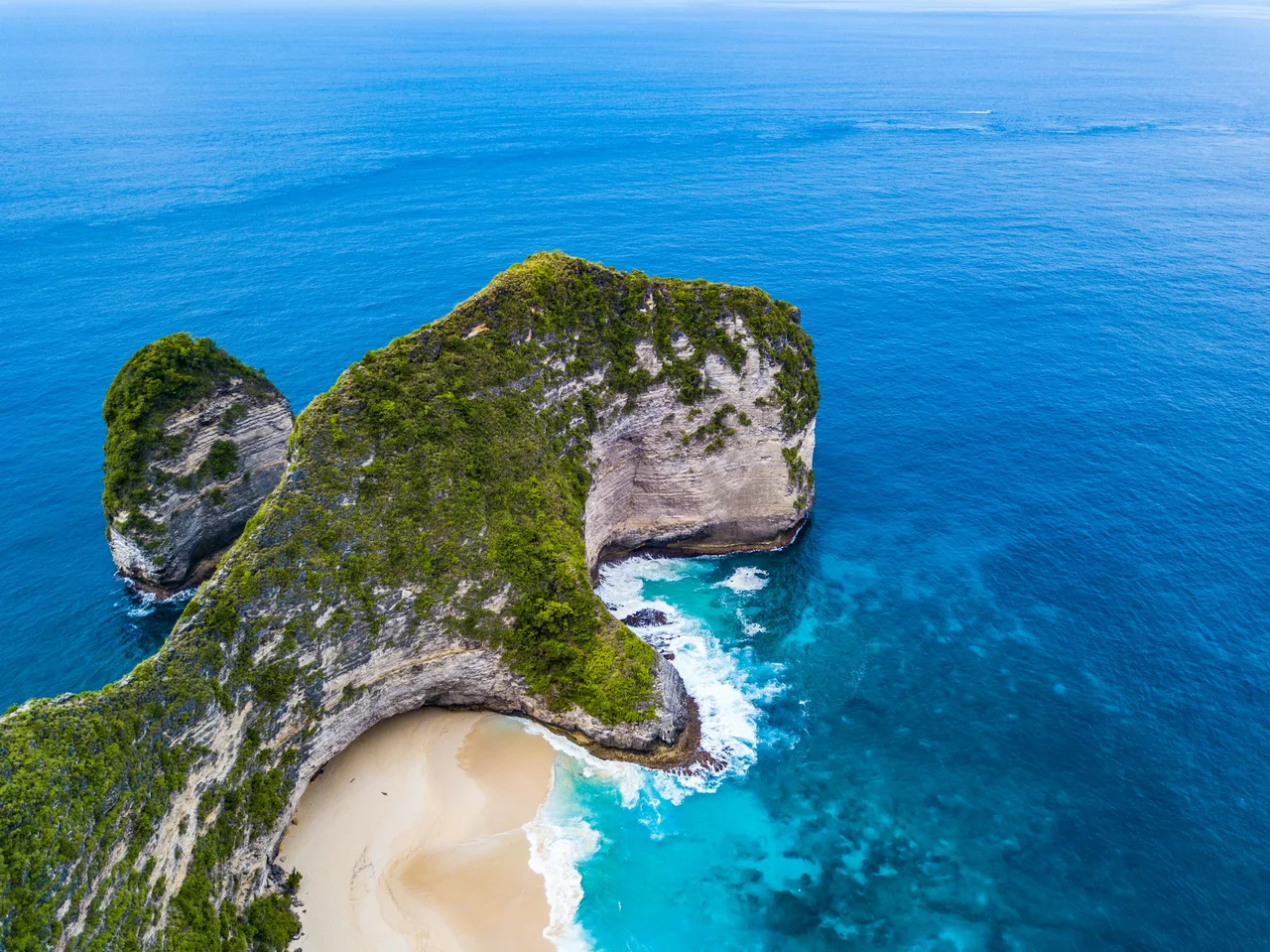 Kelingking cliffs and a white sand beach above the blue sea
