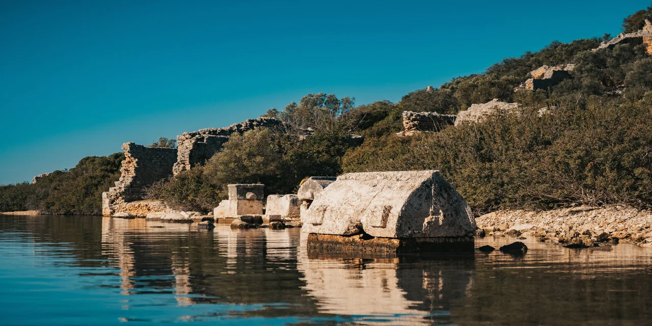 Ancient stone remains beside clear water at Aperlai