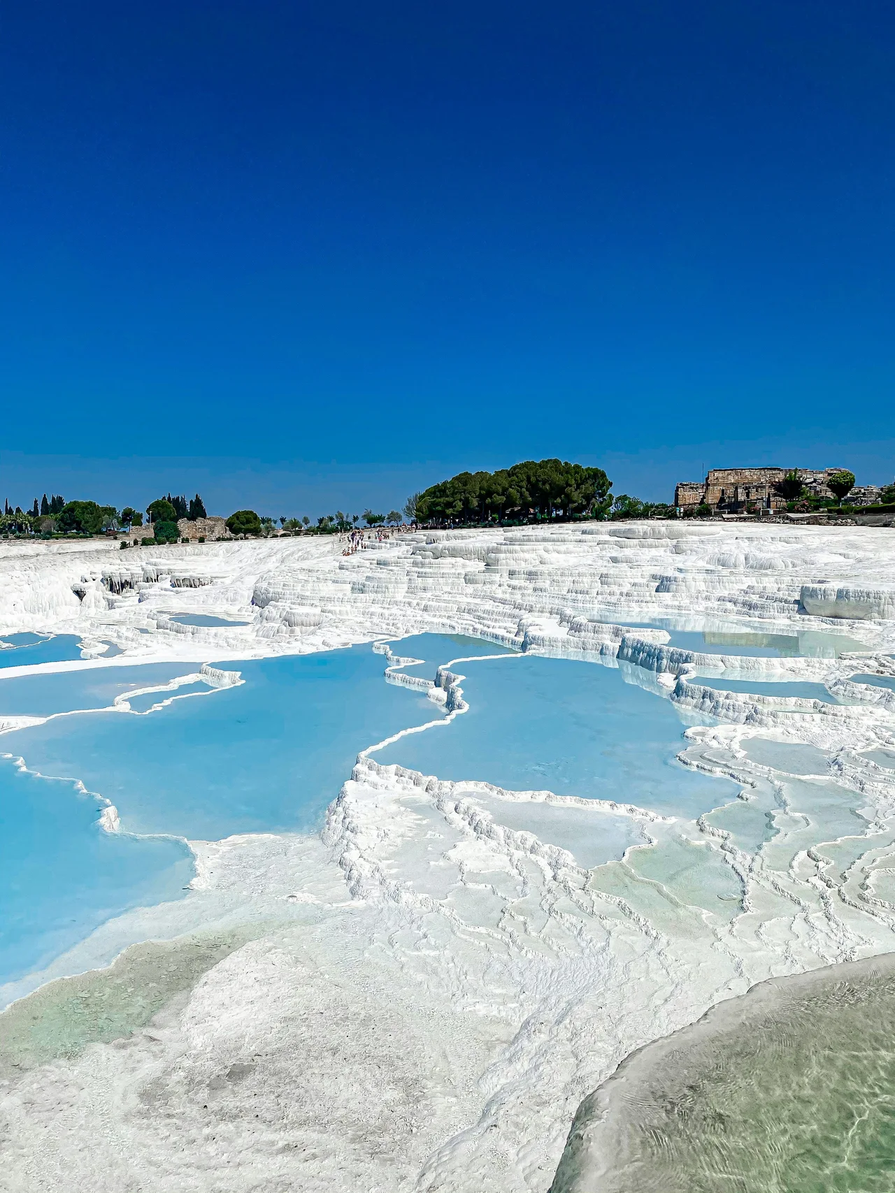 Brilliant white terraces at Pamukkale under a blue sky