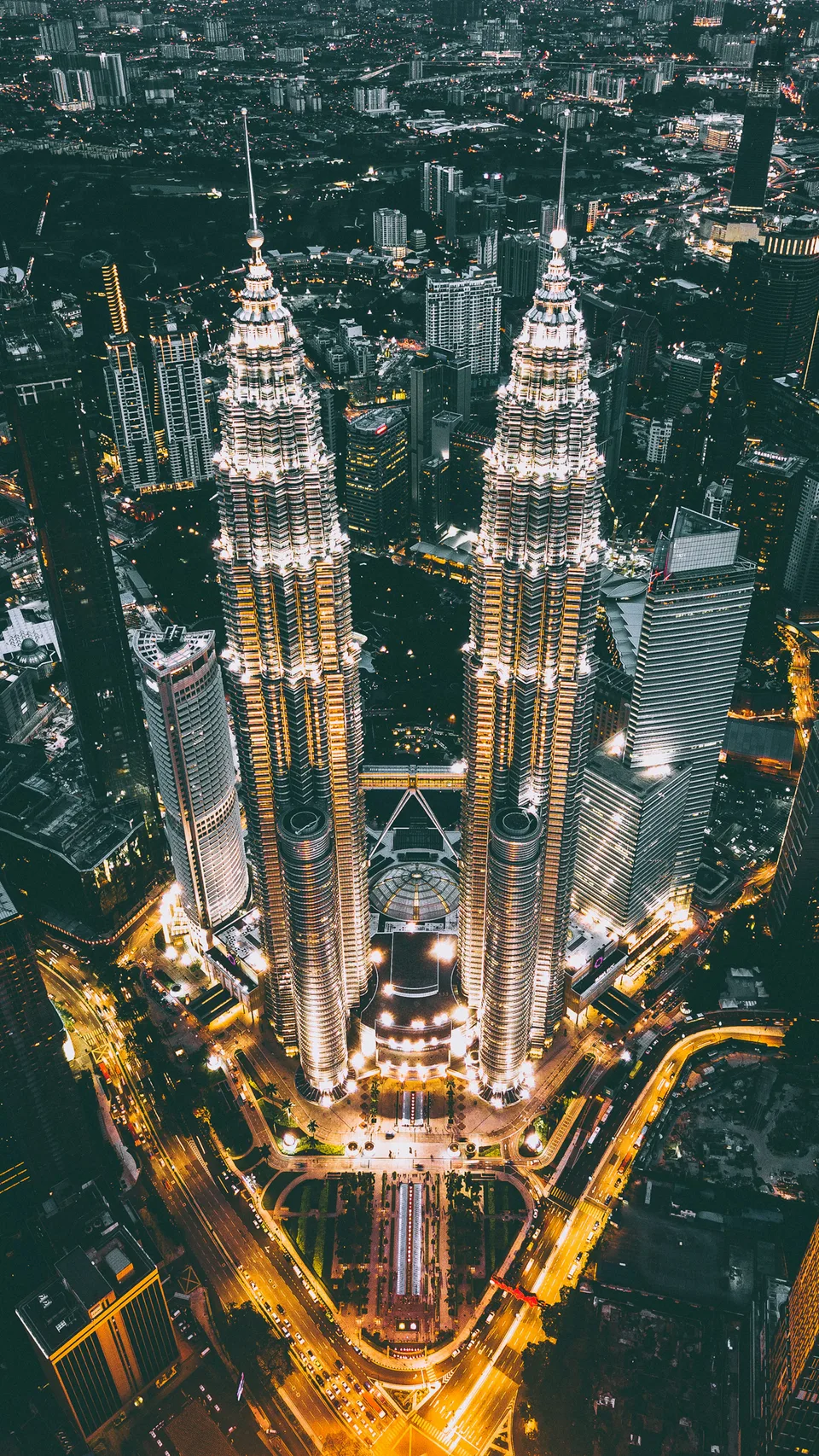 Petronas Twin Towers and city streets seen from above at night