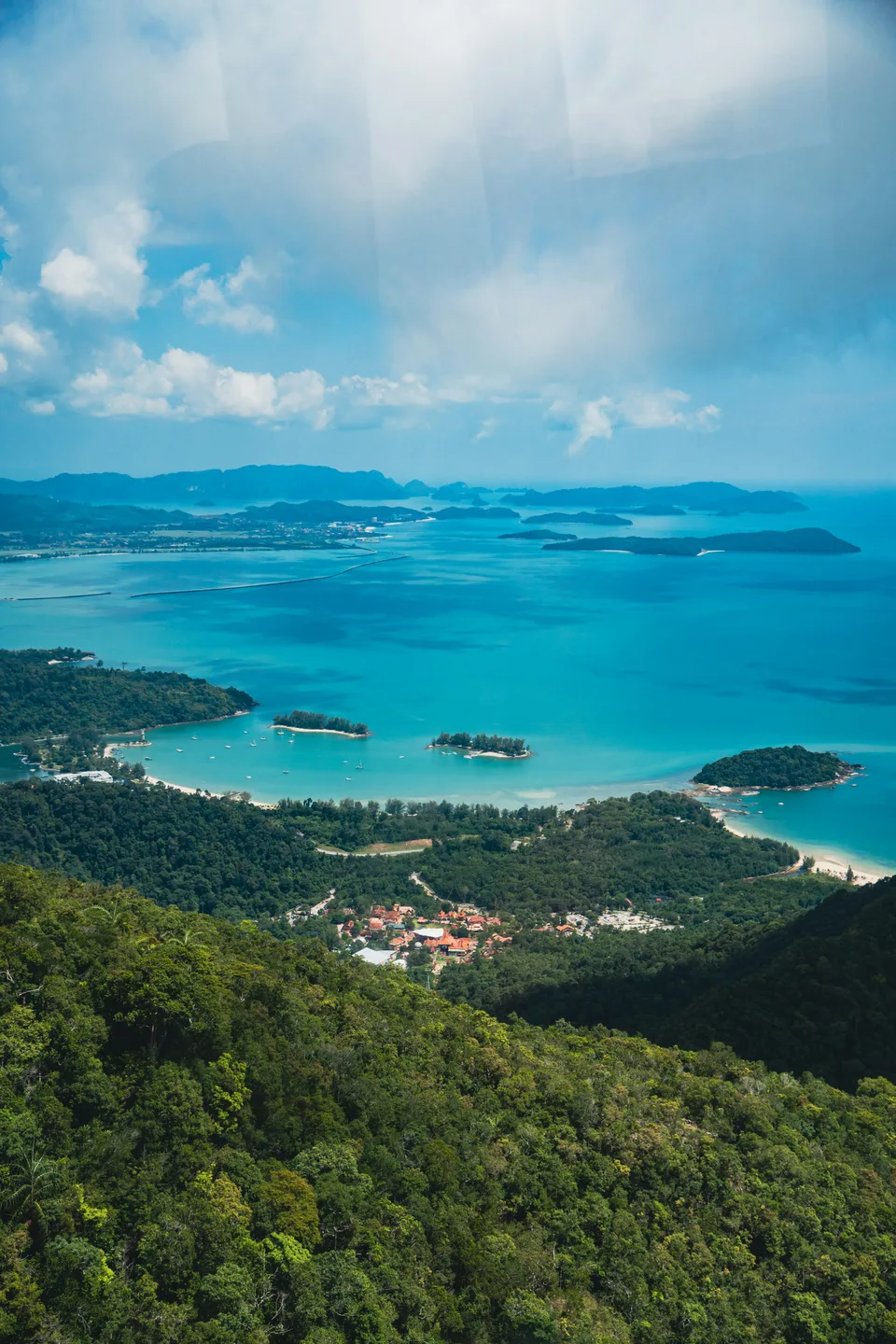 Turquoise water and tropical islands beyond a forested coastline