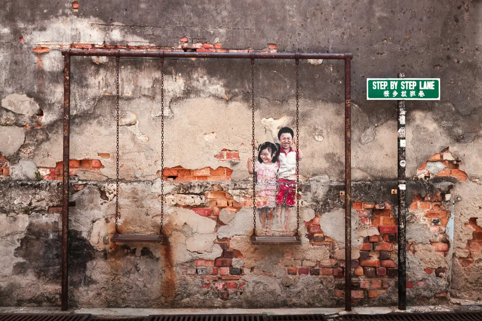 Bicycle street artwork on a weathered wall in George Town