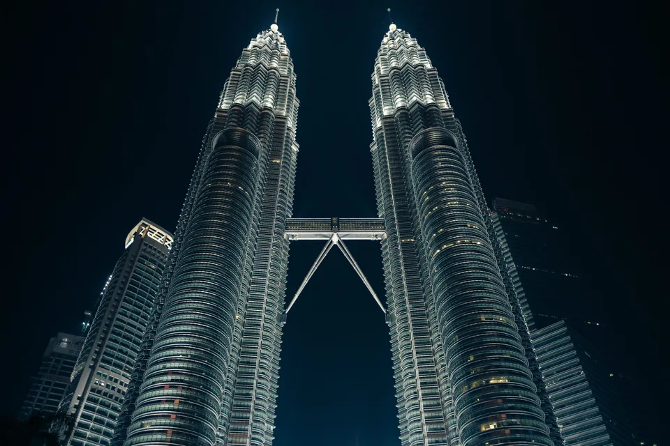 Petronas Twin Towers and skybridge illuminated against the night sky
