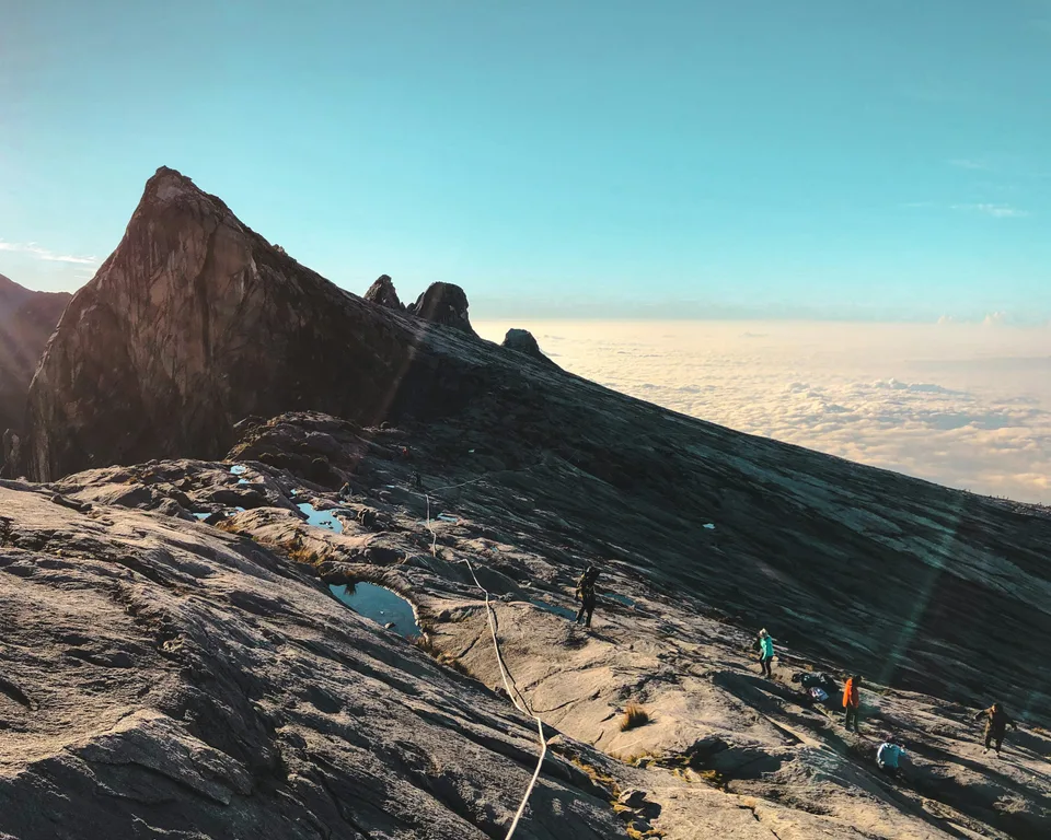 Rocky mountain summit in Sabah rising above a bank of clouds