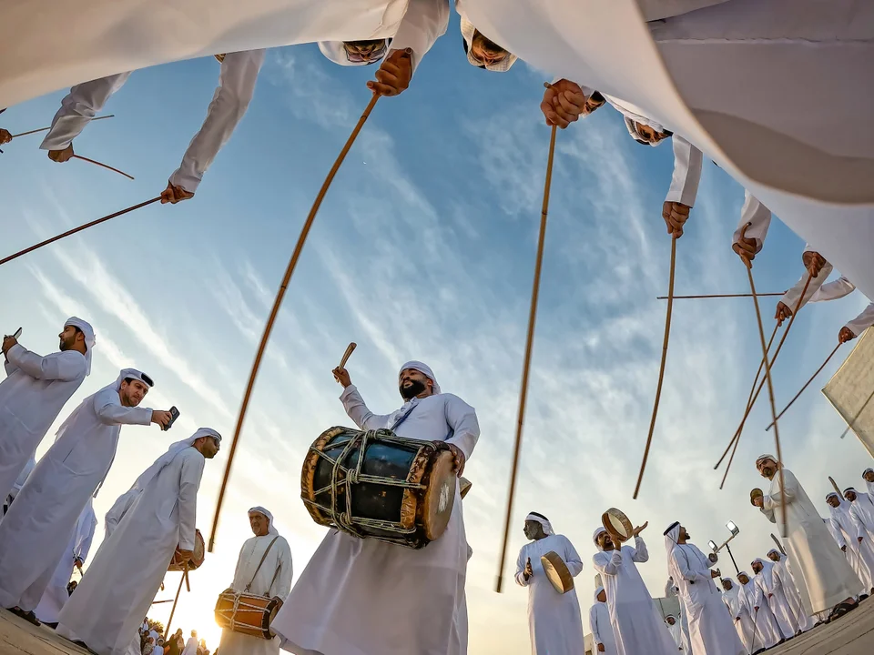 Al Ayyala performers wearing white kanduras at Al Jazirah Al Hamra Heritage Village