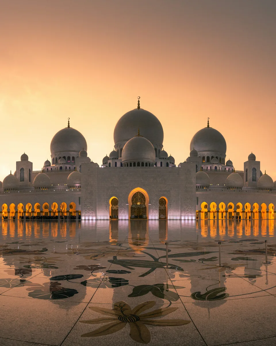 Mosque domes and reflective courtyard in warm sunset light
