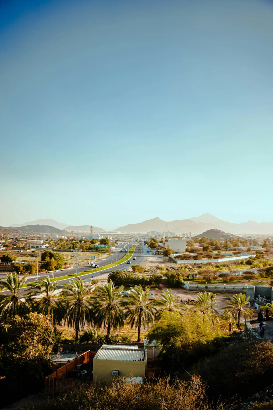 Palm groves and road winding through the mountains of Fujairah
