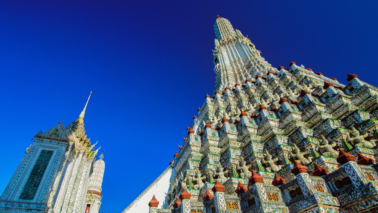 Looking up at the porcelain-tiled prang of Wat Arun in Bangkok